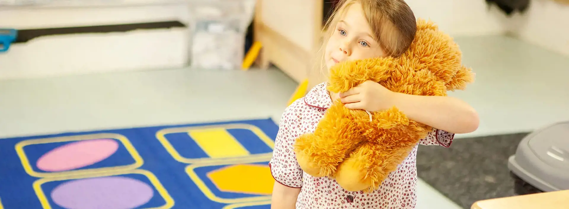 Young pupil hugging a teddy bear