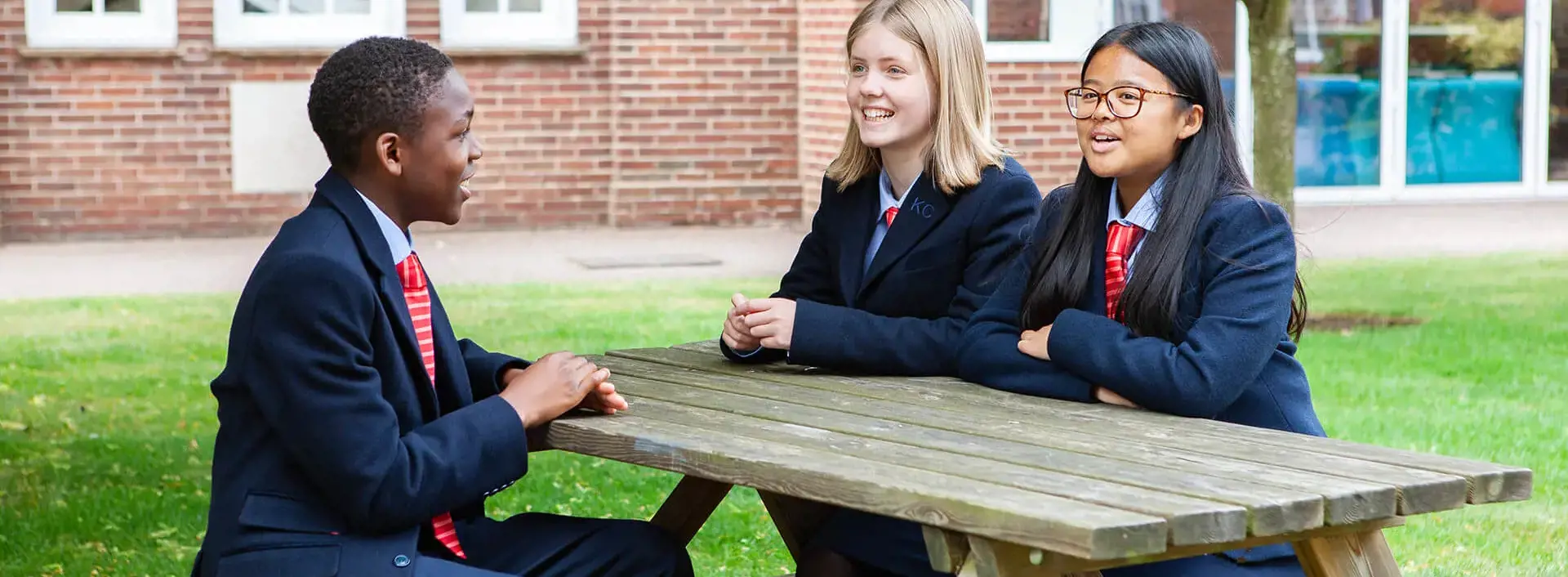 Pupils sitting in the quad on a bench
