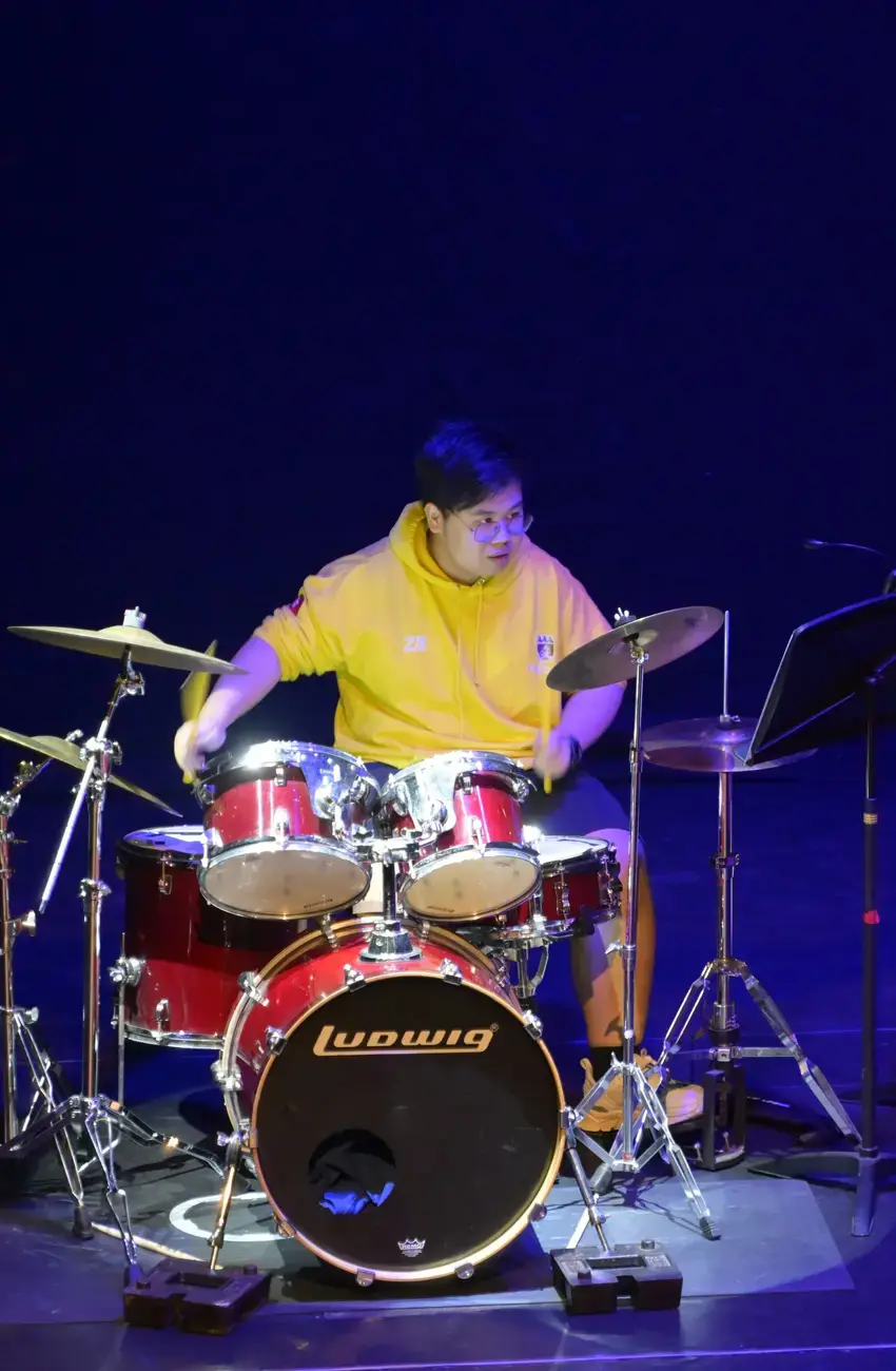 A student at Kent College playing the drums