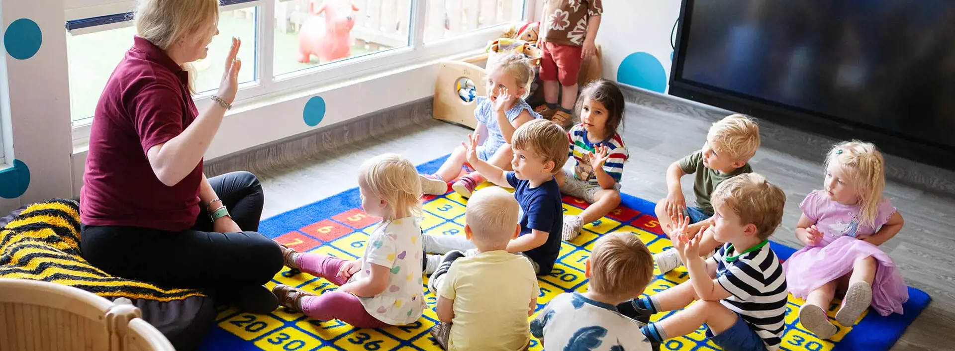 Nursery pupils on the playmat in Kent College Nursery, Canterbury